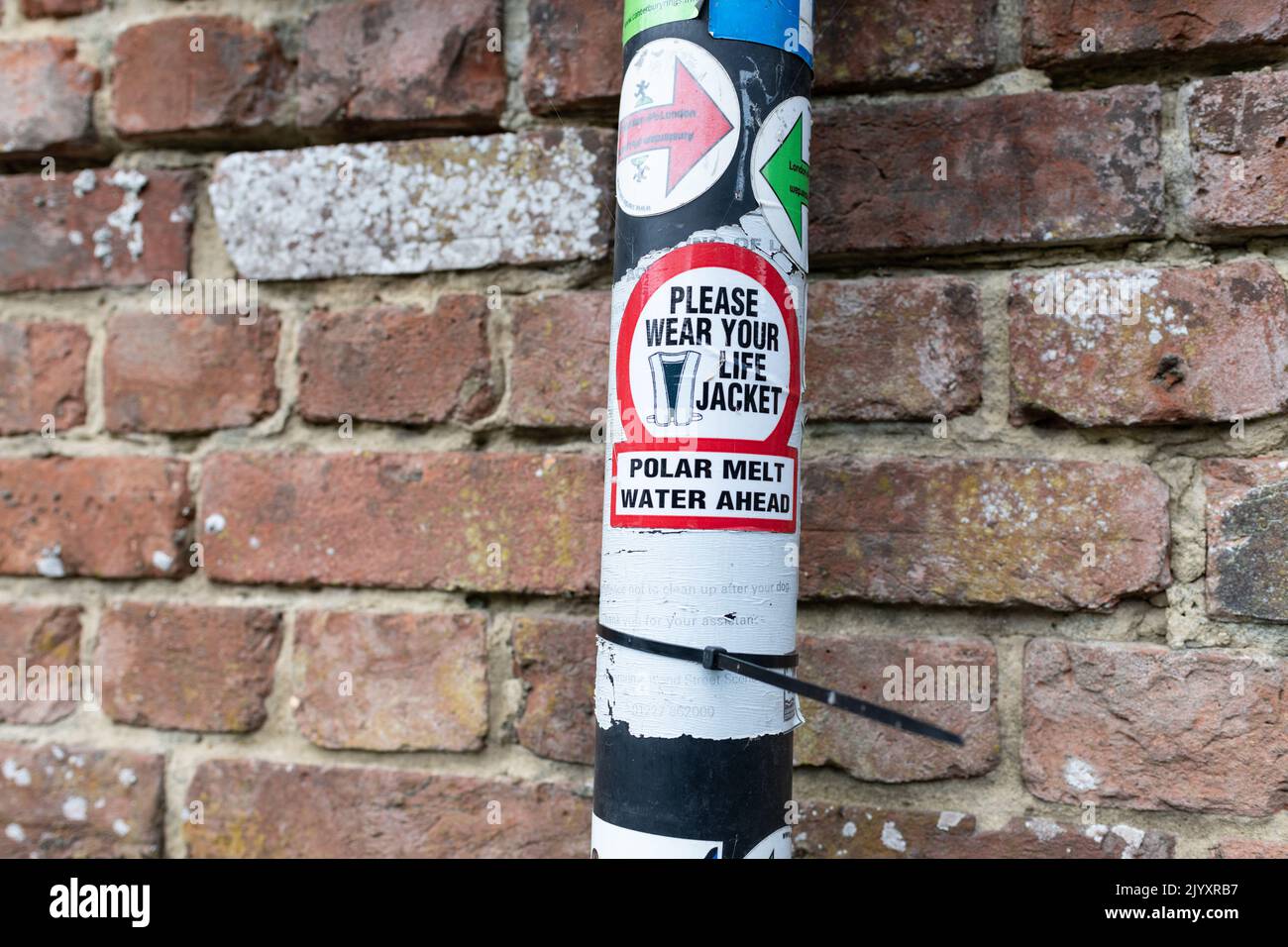 Global Warming Protest Aufkleber - Bitte tragen Sie Ihre Schwimmweste Polar Schmelze Wasser voraus - auf Post, England, Großbritannien Stockfoto