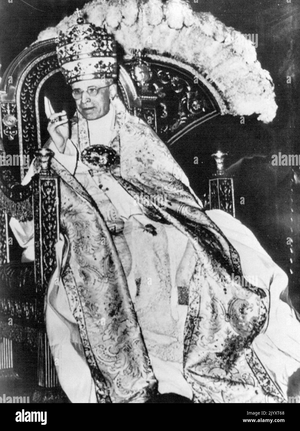 Zeichen der Genesung – Papst Pius XII. Segnet offenbar wegen seiner schwersten Krankheit die vatikanischen Massen, die sich heute zu Ehren seines 16.. Jahrestages seiner Krönung versammelten. Mehr als 5.000 Pilger packten zwei Vorzimmer der Sixtinischen Kapelle, um das Oberhaupt der römisch-katholischen Kirche zu jubeln, als er auf seinem tragbaren Thron hingetragen wurde. Es war das erste Mal seit drei Jahren, dass der heute 79-jährige Papst gut genug war, um an einer Gedenkfeier teilzunehmen. 12. März 1955. (Foto von AP Wirephoto) Stockfoto