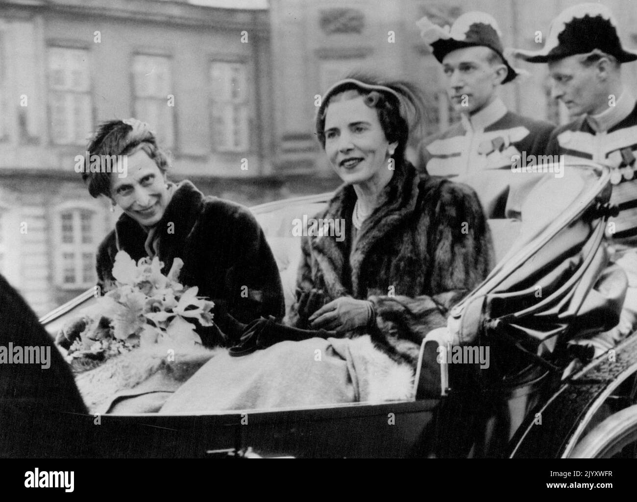 Reise der Königinnen Königin Louise von Schweden (links) würdigt den Jubel aus der Menge, als sie mit Königin Ingrid von Dänemark in Einem Staatswagen fährt. Königin Louise und König Gustaf Adolf von Schweden besuchen die dänische Königsfamilie in Kopenhagen. 26. März 1952. Stockfoto