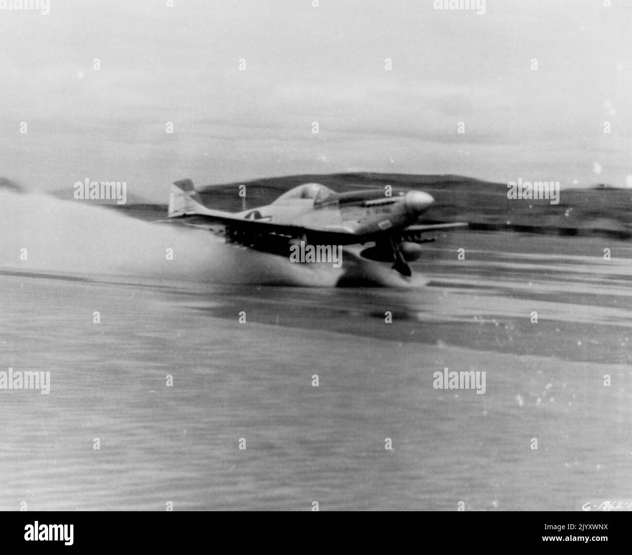 Wassergefahr -- ein Luftwaffenstützpunkt in Korea -- Wasser, das die gestreifte Stahlbahn bedeckt, stellte eine Gefahr für F-51 Mustangs des 18. Fighter Bomber Wings der Fünften Luftwaffe dar, konnte aber nicht verhindern, dass die schnellen Kampfflugzeuge zu Kampfeinsätzen startten. Hier ist eine mit Raketen und Napalm beladene Absetzung zu sehen, um einen weiteren strafenden Schlag gegen rote Ziele in Nordkorea zu verjagen. 14. August 1951. (Foto der US Air Force Photo). Stockfoto