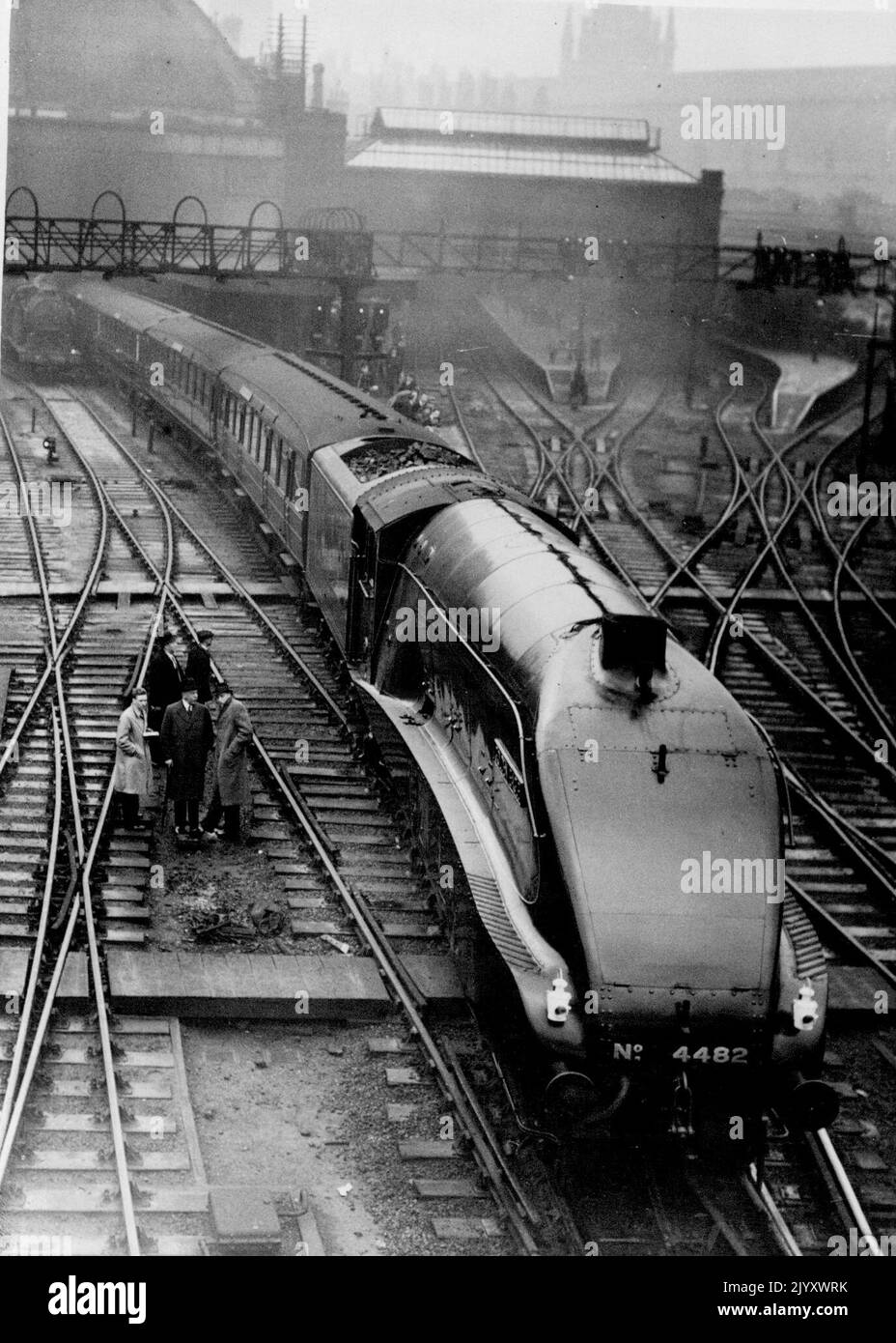 Die erste der „Coronation“-Stromlokomotiven verlässt London auf dem ersten Lauf - die „Golden Engle“, die King's Cross auf dem ersten Lauf an der Spitze des Scottish Express verlässt. Die erste der neuen stromlinderförmigen Super-Pacific-Lokomotiven, die später im Jahr den Rekord der „Krönung“ ausdrückt, verließ die „Golden Eagle“ die King's Cross Station, London, auf ihrem ersten Lauf. Die Lokomotive zog den London Edinburgh Express - einen der schwersten und schnellsten Züge des Tages - bis nach Neweastle. 6. Januar 1937. Stockfoto