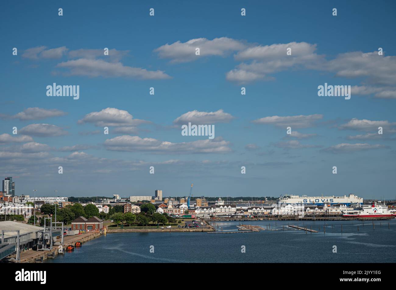 Southampton, England, Großbritannien - 7. Juli 2022: Hafenlandschaft. Red Funner Fähre Boot an seinem Dock mit Gebäude, riesige Glovis Auto Trägerschiff hinter. Alle und Stockfoto
