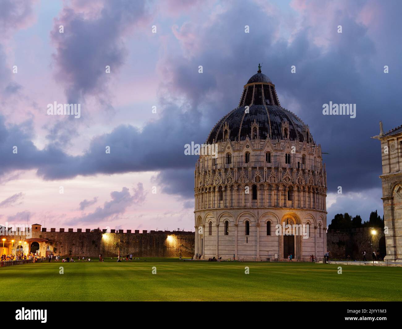 Platz der Wunder in Pisa, Toskana, Italien. Baptisterium in der Dämmerung mit einem dramatischen grau-roten Himmel. Stockfoto Platz der Wunder in Pisa, Toskana, Italien. Baptisterium in der Dämmerung mit einem dramatischen grau-roten Himmel. Stockfoto