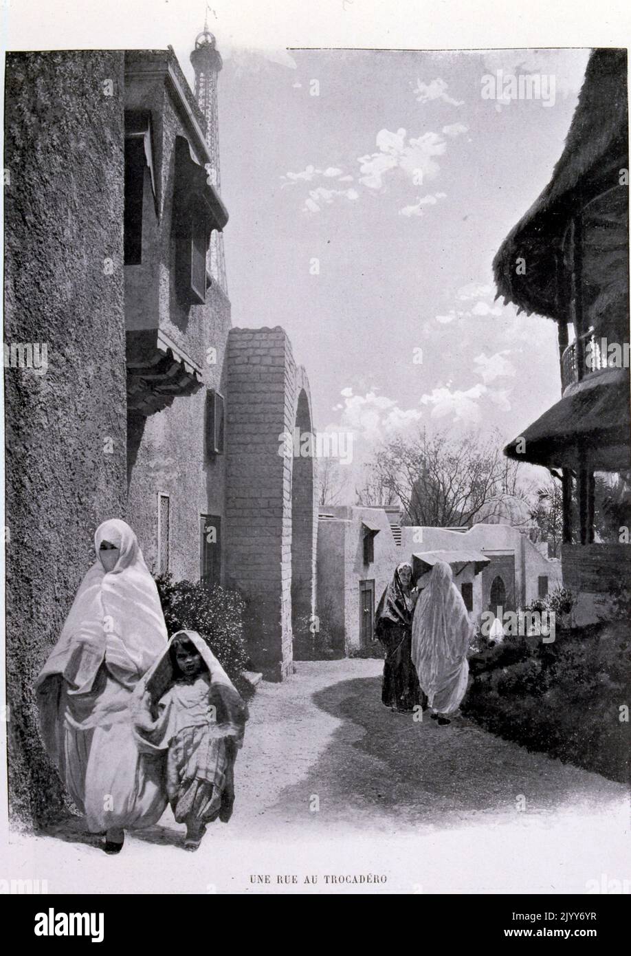 Ausstellung Universelle (Weltausstellung) Paris, 1900; Schwarz-Weiß-Fotografie einer Straße, die durch die Gärten des Trocadero führt. Indigene Frauen sind in traditioneller Tracht mit Schleiern gekleidet. Stockfoto