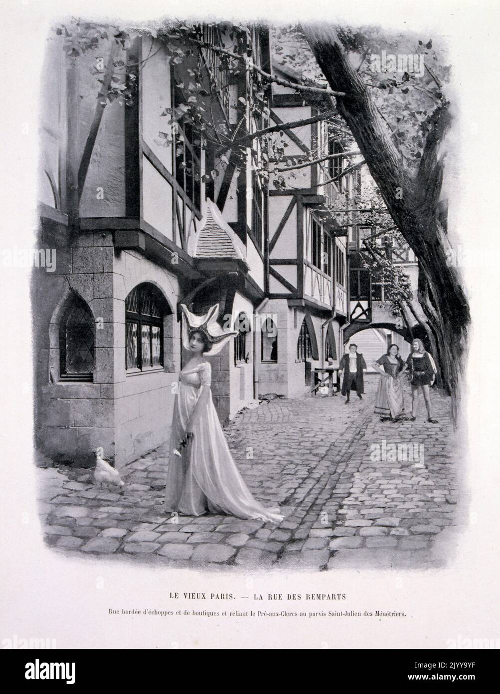 Ausstellung Universelle (Weltausstellung) Paris, 1900; Schwarz-Weiß-Fotografie der A-Straße in der Ausstellung des alten Paris in der Rue des Remparts, einschließlich Menschen, die in historischen Kostümen auf der Straße spazieren. Stockfoto