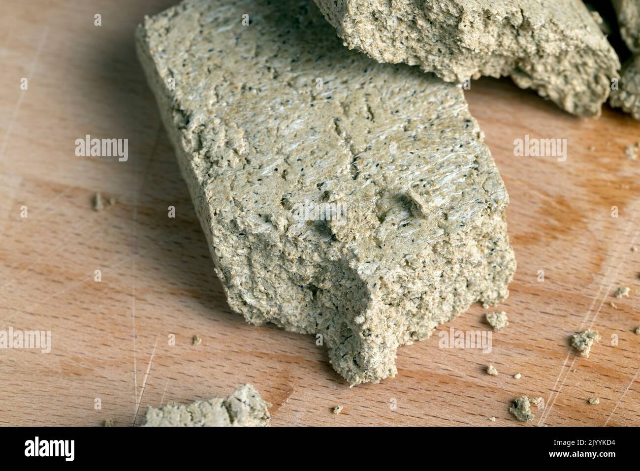 Sonnenblumenhalva zerbrochen in Stücke, Stücke von Halva Süßigkeiten auf einem Holzbrett Stockfoto