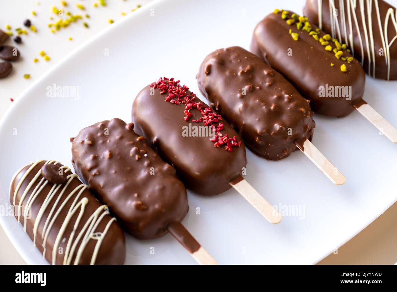 Kekse auf einem Stock in Form von Eis.appetitliche Cupcakes und Gebäck.Cupcake-Eis mit Schokoladencreme.Choux Gebäck. Cupcakes aus Schokolade Stockfoto