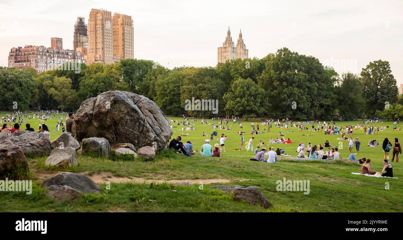 Menschen in Central Park, Manhattan, New York City, USA am Ende eines Sommertages Stockfoto