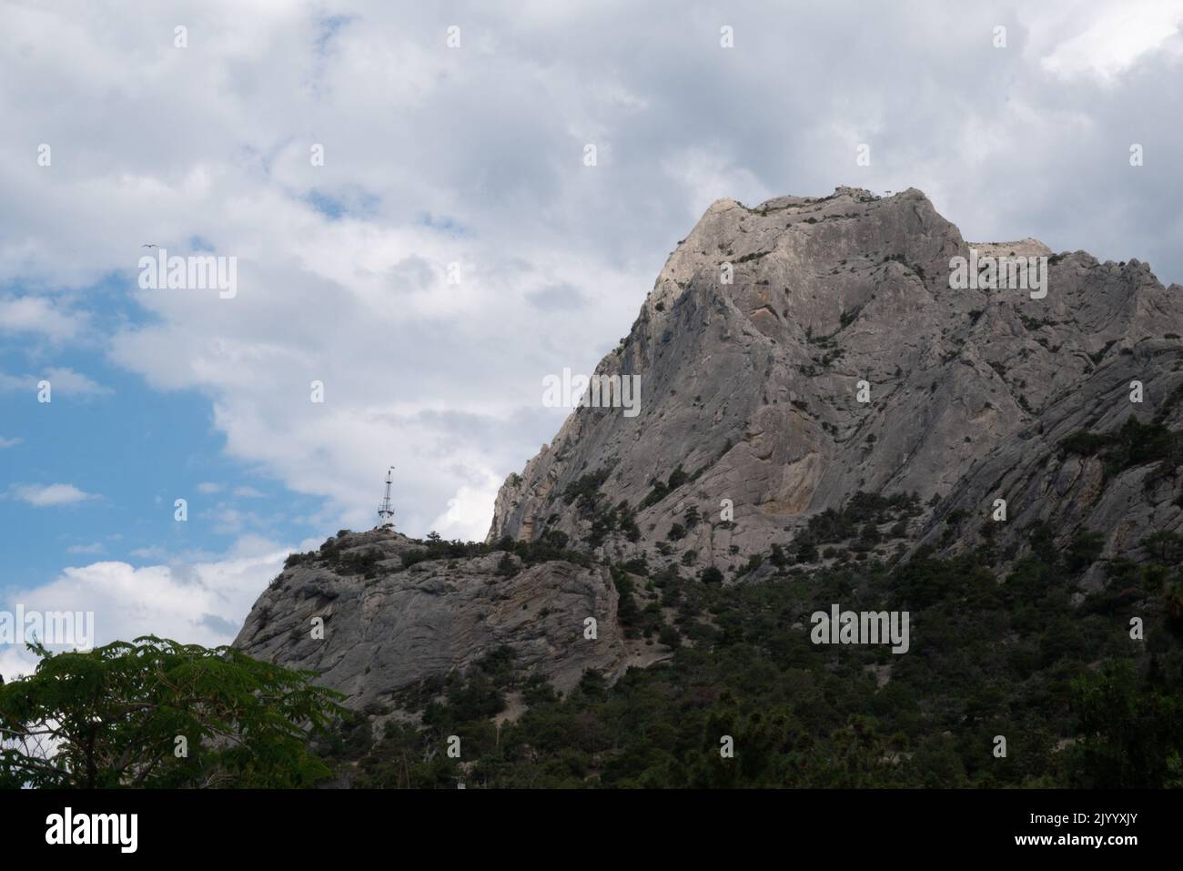 Ein großer felsiger Berg gegen einen bewölkten Himmel. Stockfoto