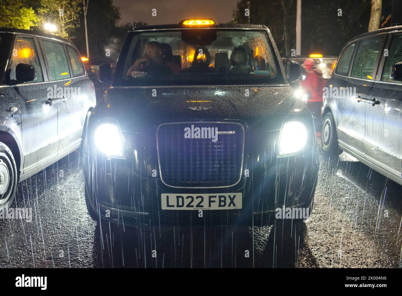 London, Großbritannien, 8.. September 2022. Schwarze Taxis und ihre Fahrer stehen an der Mall, um ihrer Majestät der Königin ihren Respekt zu erweisen. Mitglieder der Öffentlichkeit versammelten sich vor ihrer Londoner Residenz, dem Buckingham Palace, bis spät in die Nacht, nachdem ihr Tod am frühen Abend bekannt gegeben wurde. Das Land wird nun zehn Tage lang trauern, da die 70-jährige Regierungszeit des Monarchen zu Ende geht. Quelle: Elft Hour Photography/Alamy Live News Stockfoto