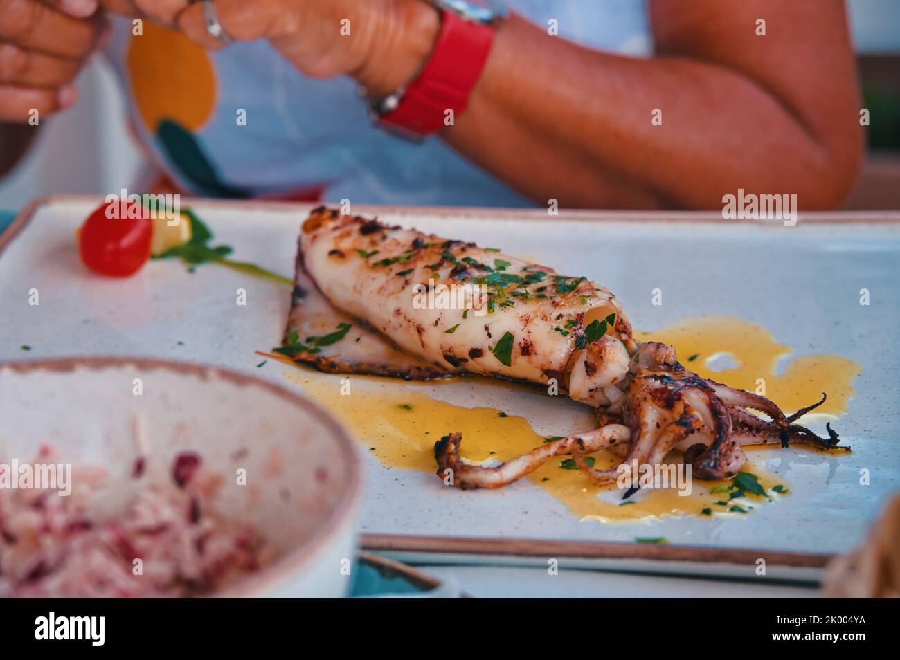 Im Restaurant wird Calamari auf dem Tisch serviert Stockfoto