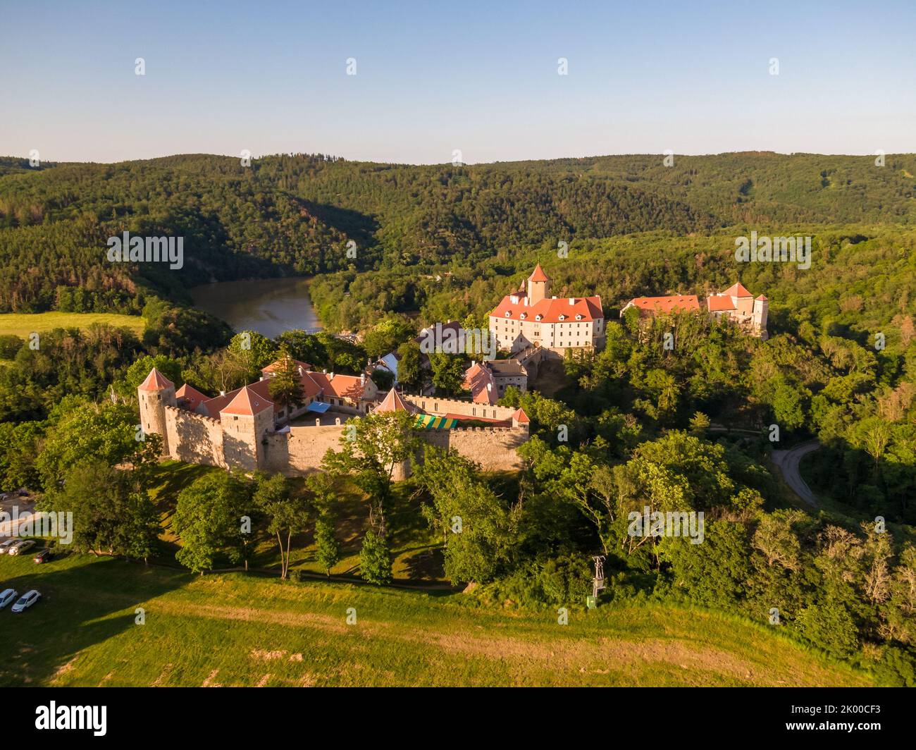 Luftaufnahme der Burg Veveri in der Nähe der Stadt Brünn. Region Südmähren, umgeben vom Fluss Svratka. Sommertag mit blauem Himmel, Sonnenuntergang und sanftem Licht. Stockfoto