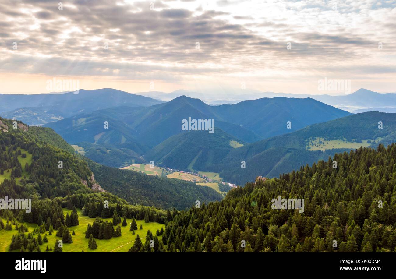 Luftaufnahme zum Mala Fatra Gebirge in der Slowakei. Sonnenaufgang über Berggipfeln und Hügeln in der Ferne. Schöne Natur, lebendige Farben. Berühmte touristische Desti Stockfoto