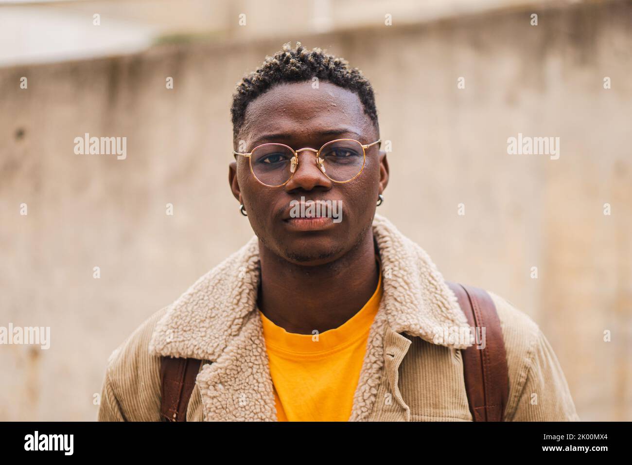 Junge afroamerikanische Studentin, die ernsthaft auf die Kamera schaut, die aus der High School heraussteht. Nahaufnahme eines schicken Teenagers mit schönen Fotos Stockfoto