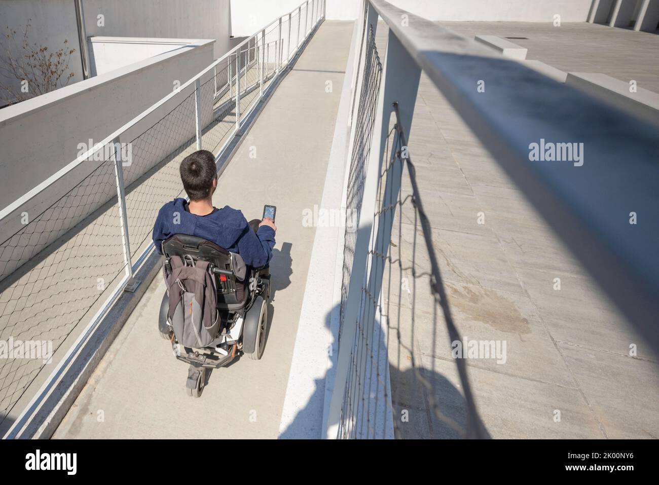 Mann im Rollstuhl nutzt eine zugängliche Rampe. Stockfoto