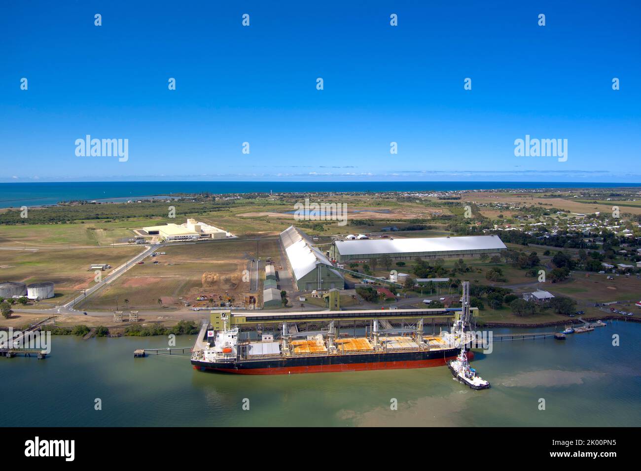 Luftaufnahme eines Frachtschiffes, das an einem Terminal an der Küste mit tiefblauem Himmel über Port Bundaberg Qld Australia geladen wird Stockfoto