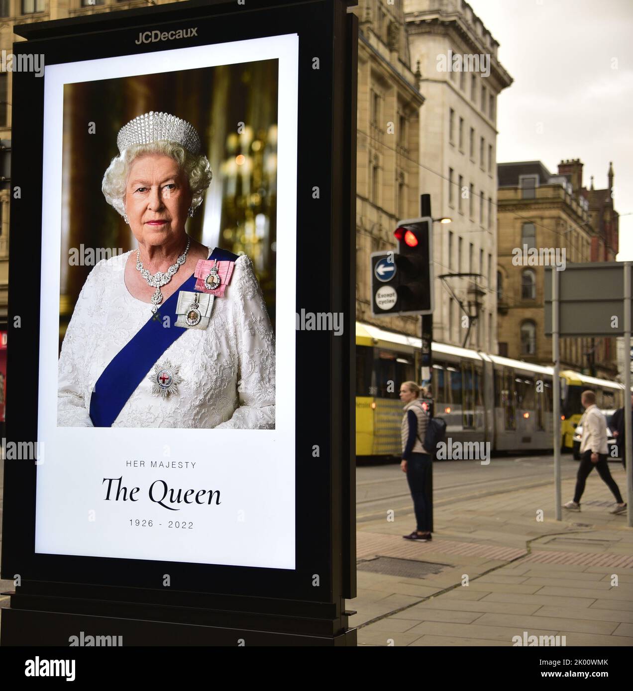 Manchester, Großbritannien, 9.. September 2022. Die Menschen gehen in Manchester, Großbritannien, an elektronischen Werbetafeln vorbei, auf denen Ihre Majestät, Königin Elizabeth II, zu sehen ist. Ihre Majestät, die Königin, starb im Alter von 96 Jahren am 8.. 2022. Der Stadtrat von Manchester hat auf seiner Website gesagt, dass die Stadt Manchester die offizielle 10-tägige Trauerperiode beobachten wird und dass: „Die Bewohner könnten Blumen zum Gedenken an den Tod Ihrer Majestät legen wollen. Am St. Ann's Square können Sie Blumen legen. Quelle: Terry Waller/Alamy Live News Stockfoto