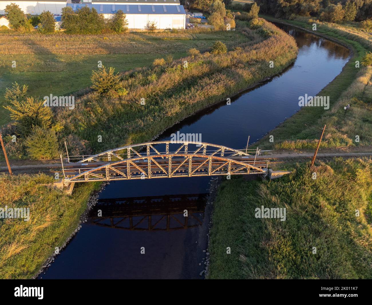 Alte Stahl-Straßenbahnbrücke über den Fluss Ner in der Stadt Lutomiersk, Polen. Stockfoto