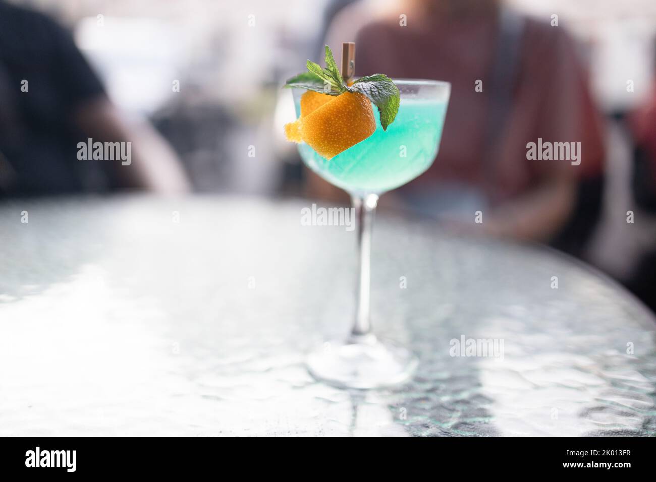 Leckerer Blue Lagoon Cocktail auf hellgrauem Tisch, im Freien Stockfoto