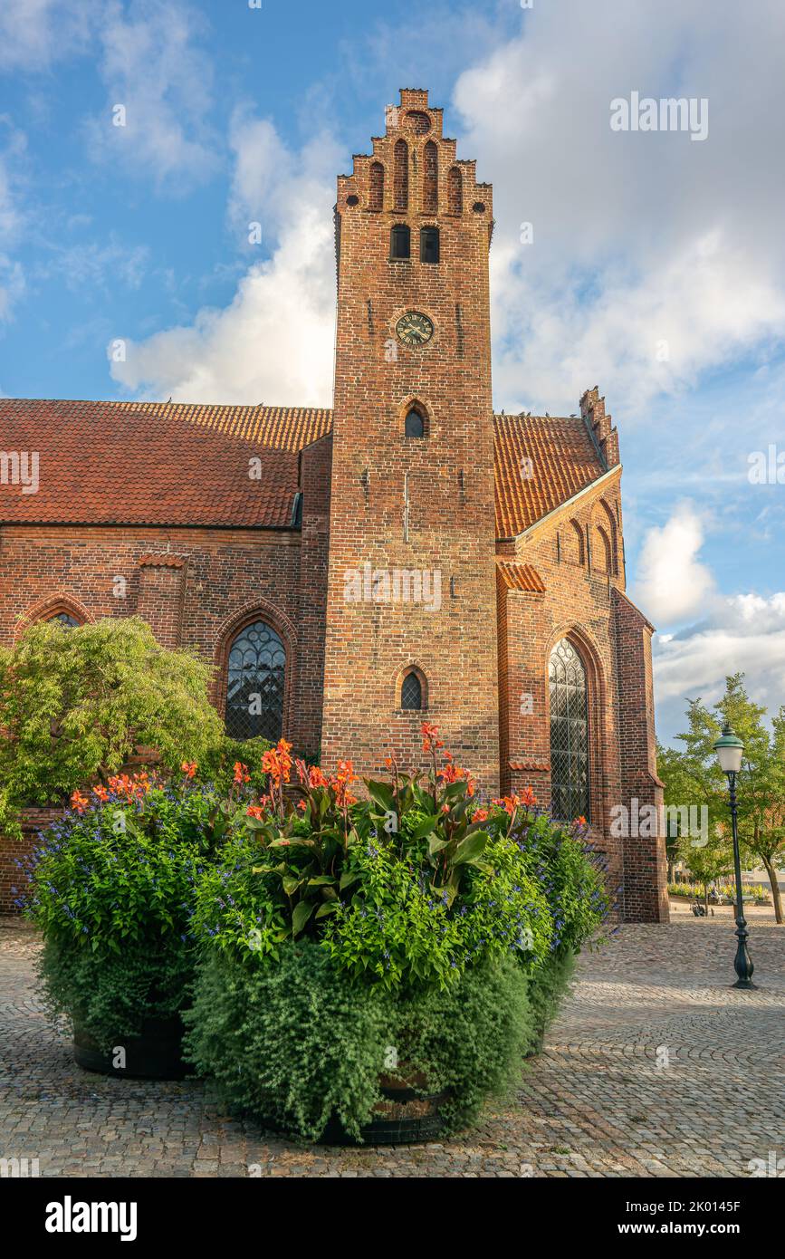 Ystad, Schweden - 6 Sep, 2022: Altes rotes gemauertes Kloster mit Kopfsteinpflaster und Topfpflanzen als Dekoration. Stockfoto
