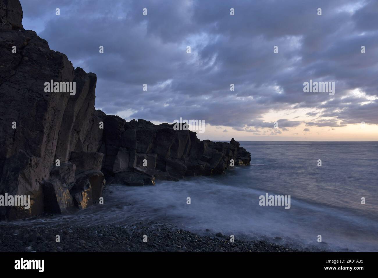 Vulkanische Gesteinsformationen an der Küste des Atlantischen Ozeans in der Abenddämmerung, Strand Praia Formosa in der Nähe von Funchal Madeira Portugal. Stockfoto