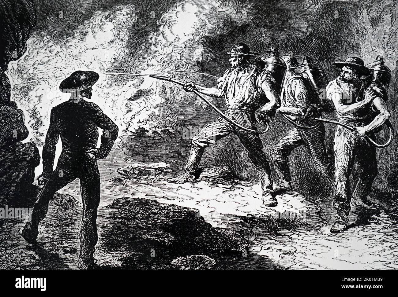 Männer, die einen Brand in einer Mine mit tragbaren Feuerlöschern bekämpfen. Stockfoto