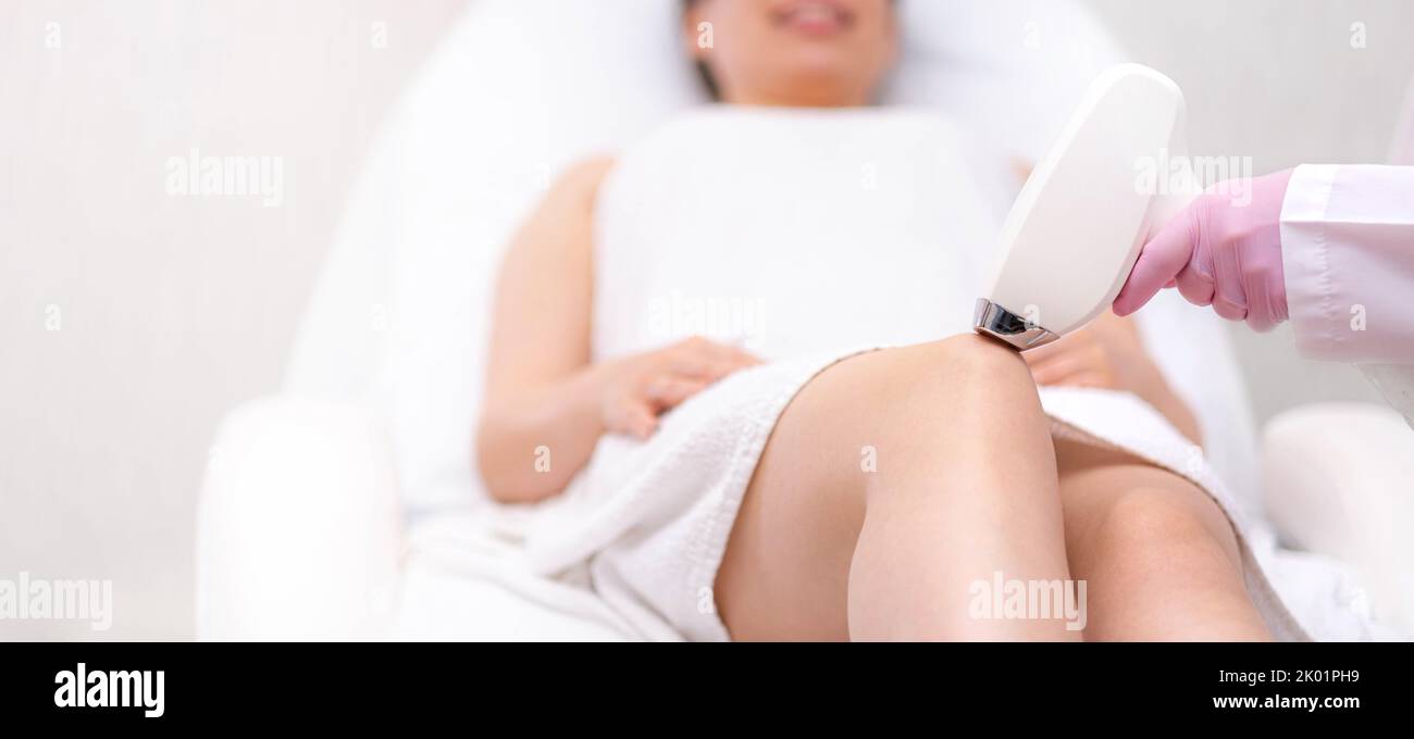 Banner Diode Laser Haarentfernung, Kosmetikerin entfernt Haare auf schönen weiblichen Beinen, Haarentfernung für glatte Haut, Laser-Verfahren im Beauty-Studio oder Stockfoto