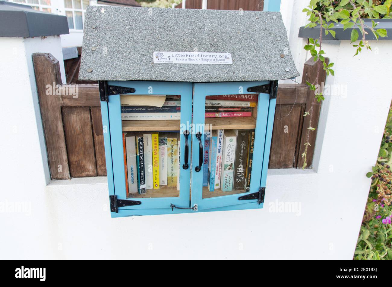 Little Free Library ein gemeinnütziger Bücherkoffer in der Nähe eines Parks Stockfoto