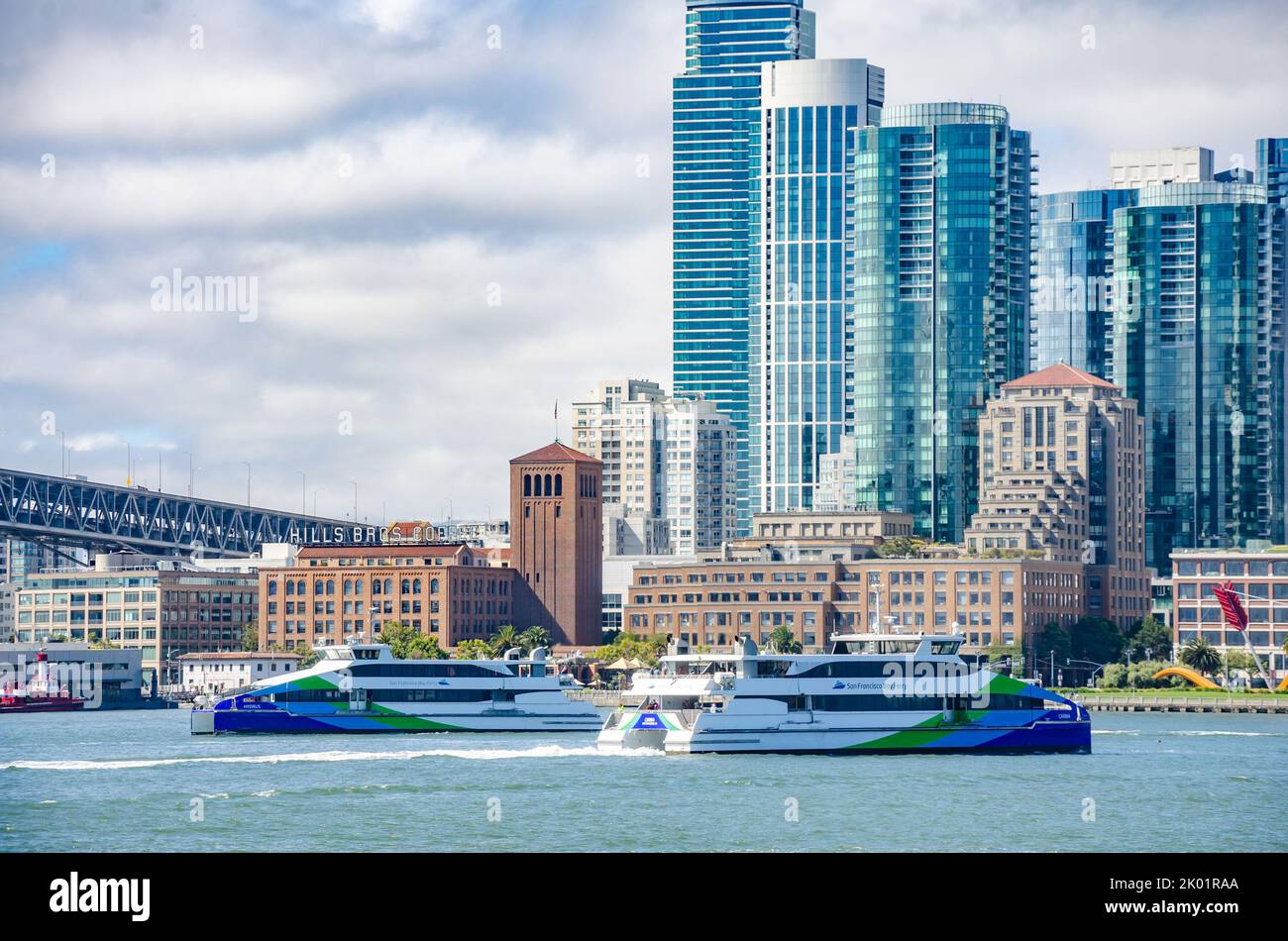 Die San Francisco Bay Ferries überqueren Wege vor der Kulisse von San Francisco selbst. Stockfoto