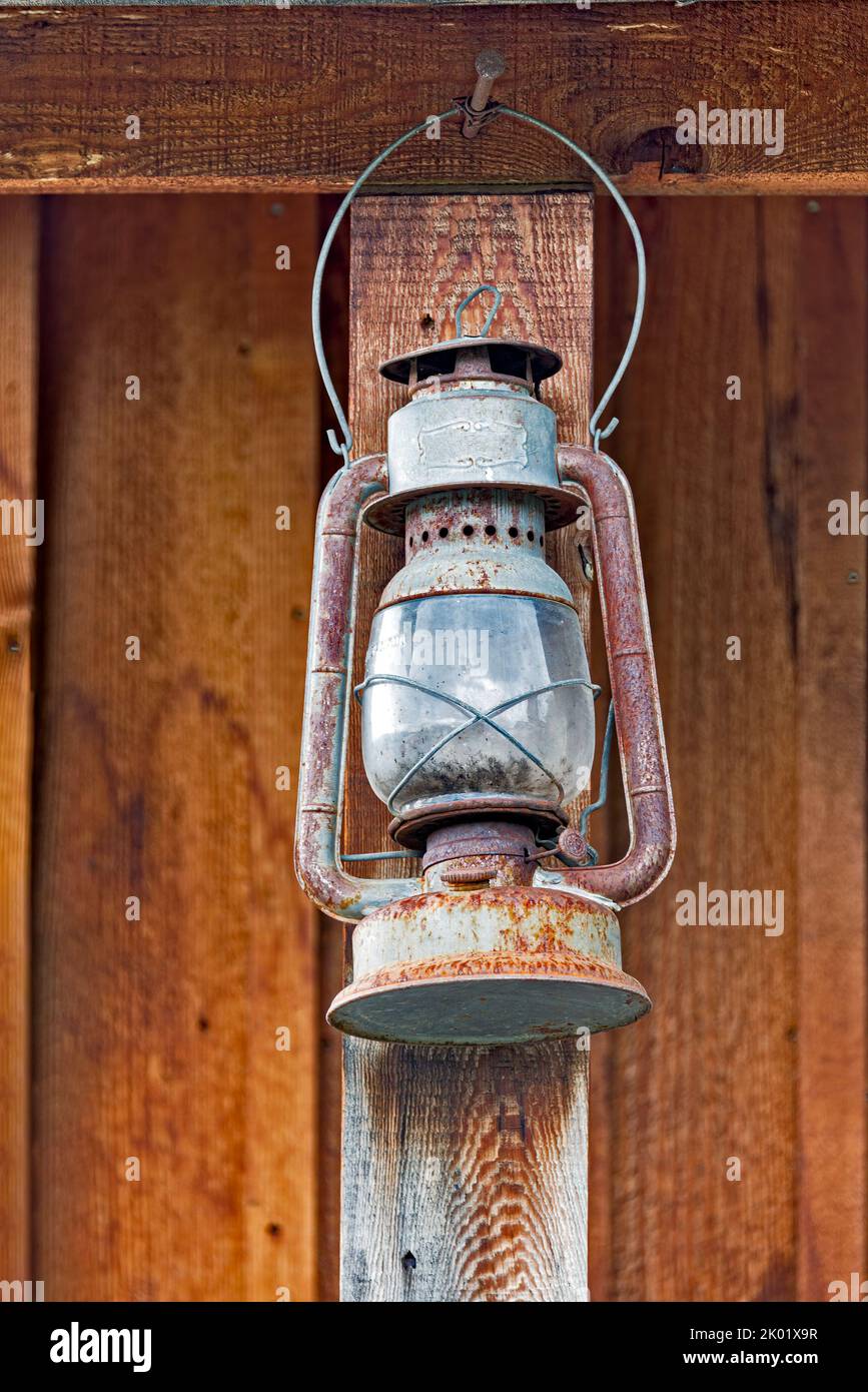 Alte rostige Öllampe unter dem Sommerholzschuppen Stockfoto