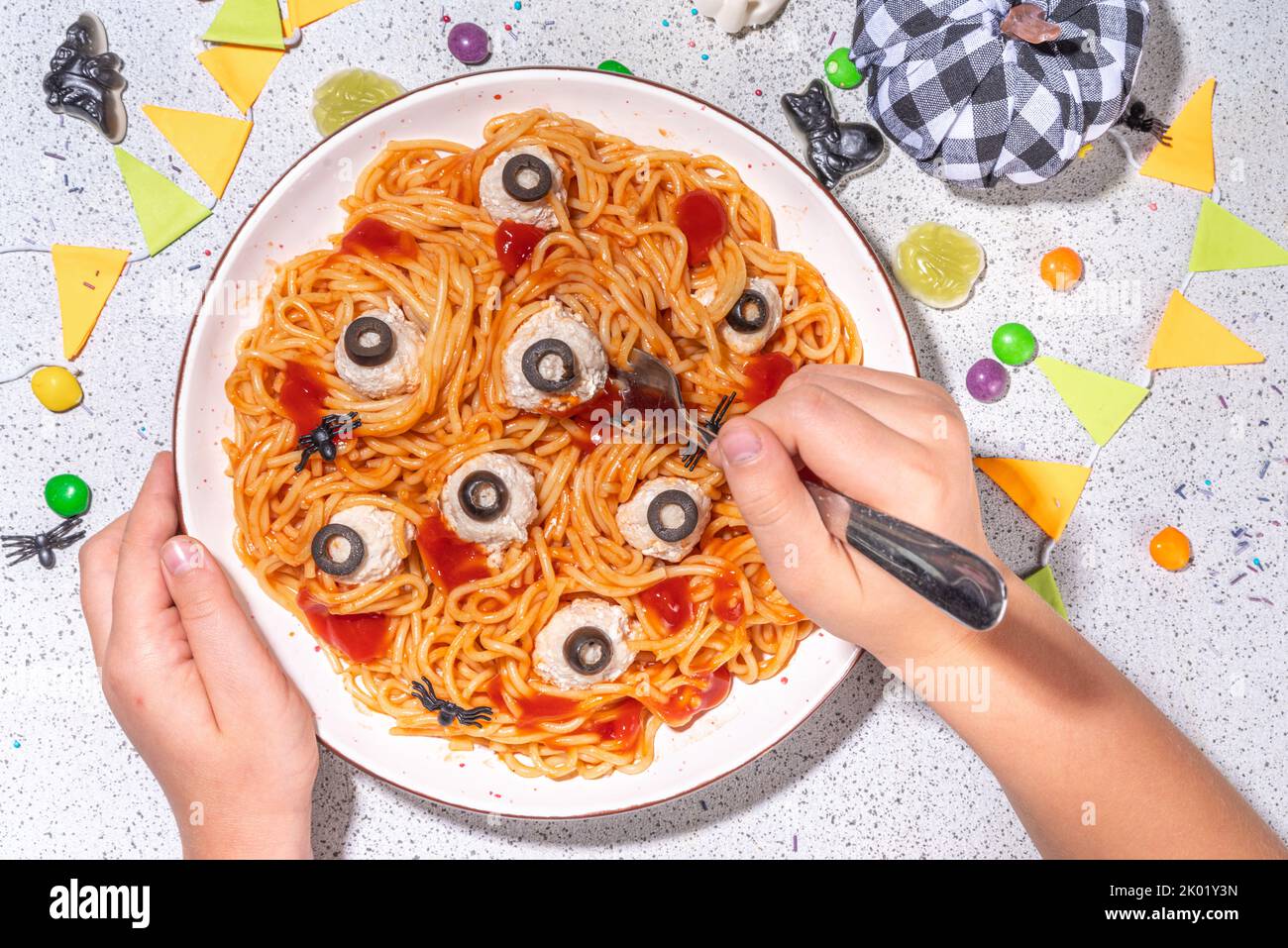 Gruselige lustige Pasta Spaghetti für Halloween Party Dinner. Spaghetti mit Tomatensauce und Hühnerfleischball, verziert mit schwarzen Oliven wie Augen, weiß Stockfoto