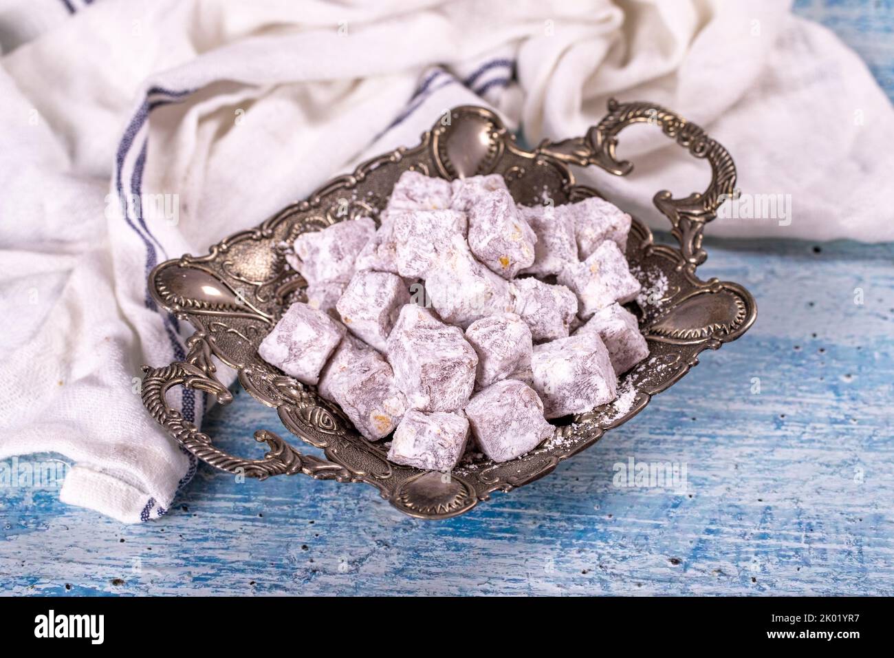 Türkische Freude mit Pistazie. Süßer türkischer Genuss auf blauem Hintergrund. Traditionelle türkische Delikatessen. Nahaufnahme Stockfoto