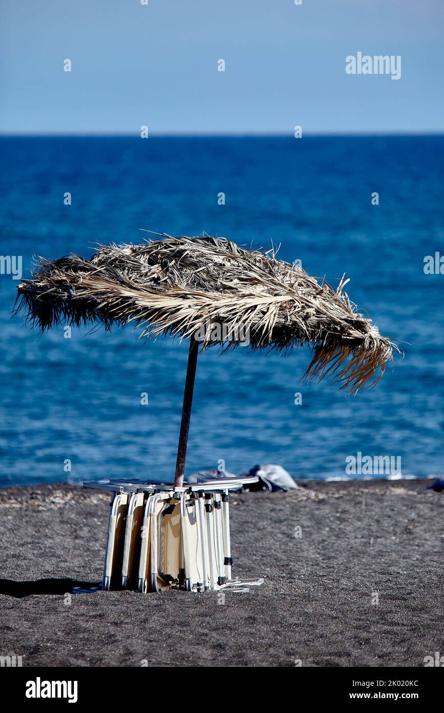 Perivilos Beach ist ein berühmter Ort für Hochzeitsempfänge und das kosmopolitischste und lebhafteste Strandresort in Santorini, das aus schwarzem Lavasand besteht. Stockfoto