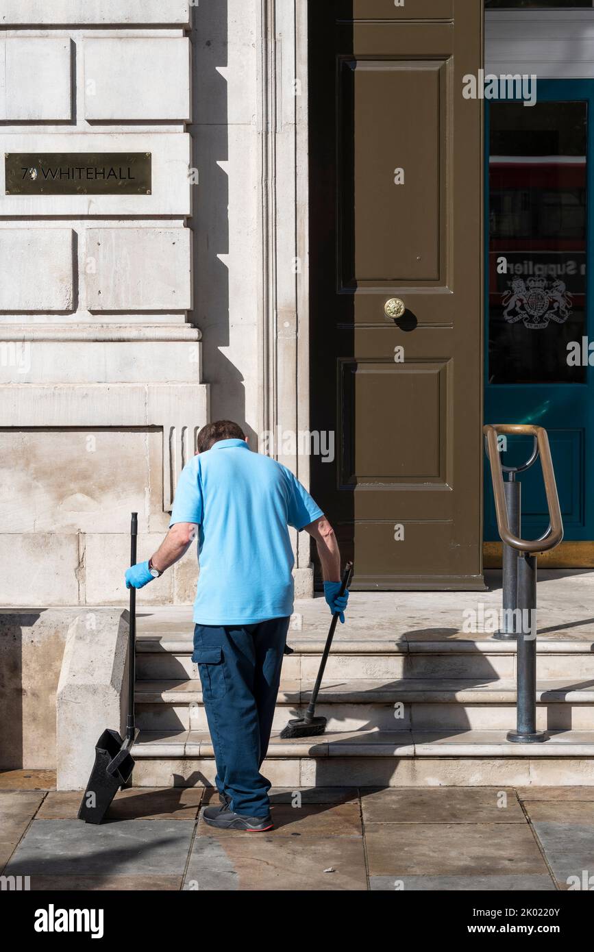 Neues Besenkonzept. Arbeiter fegen Blätter und Zigarettenkippen vor dem Kabinett, 70 Whitehall, Westminster, London, Großbritannien Stockfoto Neues Besenkonzept. Arbeiter fegen Blätter und Zigarettenkippen vor dem Kabinett, 70 Whitehall, Westminster, London, Großbritannien Stockfoto