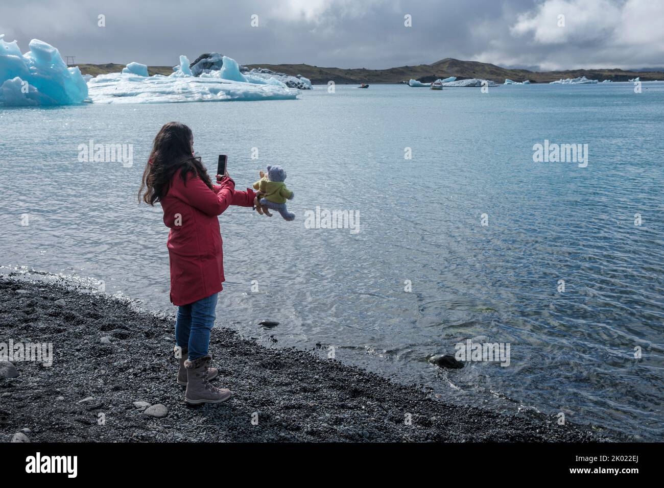 Eine Touristin fotografiert ihre Teddybären an der Jokulsarlon Gletscherlagune in Island Stockfoto