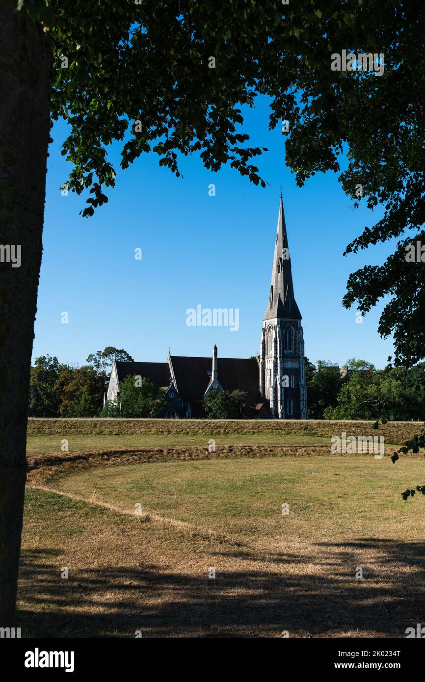 St Alban's Church (Englische Kirche) in Kopenhagen, Dänemark, eingerahmt von Baumstamm und Ästen Stockfoto