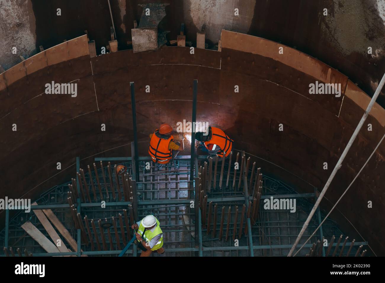 Tatarstan, Russland. 26. August 2022. Bau einer Brückenstütze in der Aushöhlung mitten im Fluss. Schweißen von Armaturen. Arbeiter am Boden der Ausgrabung, Blick von oben. Stockfoto