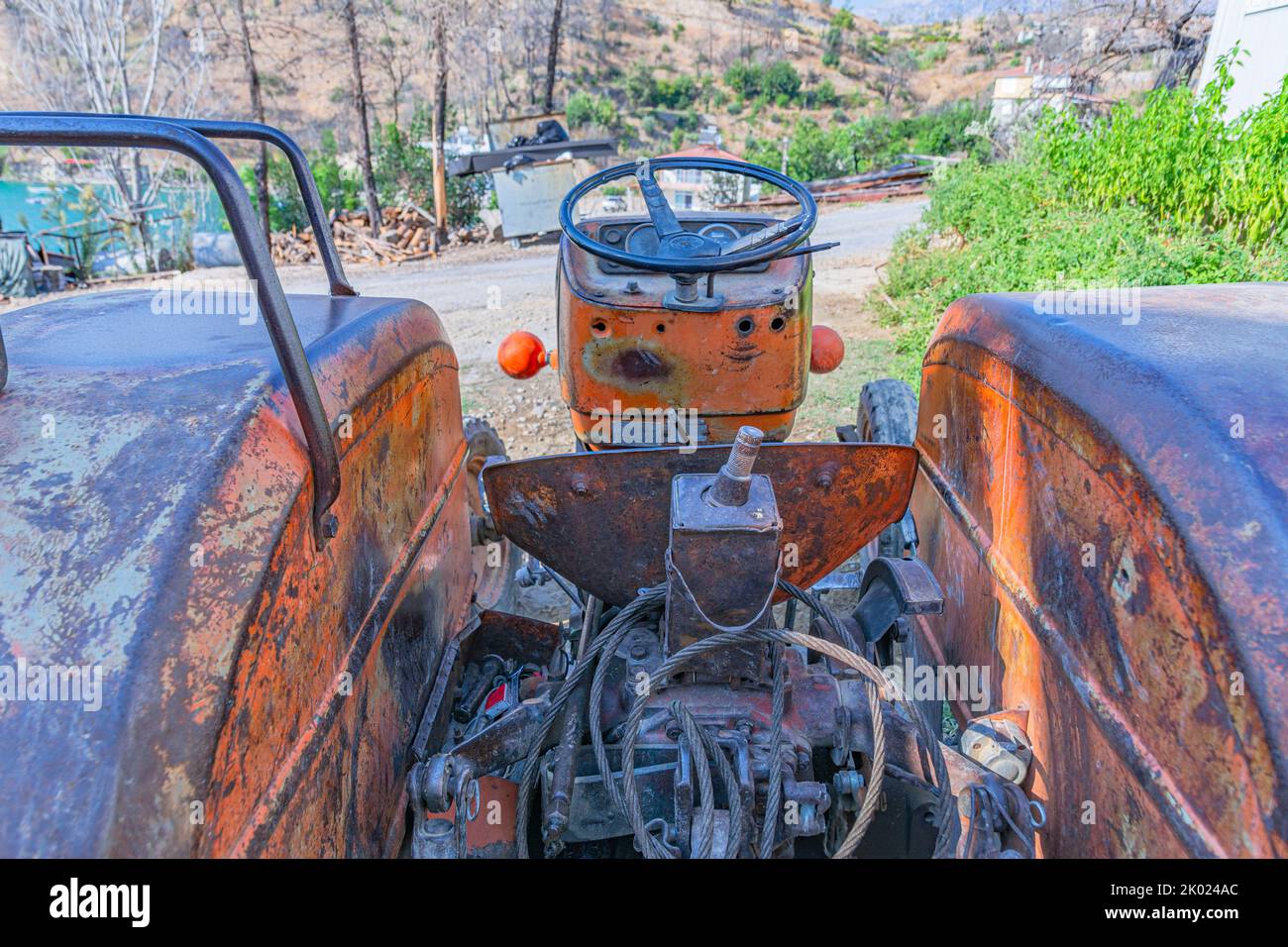 Alte rote Oldtimer-Traktor mit offenem Fahrerhaus. Foto eines ländlichen Traktors ohne Fahrerhaus. Nahaufnahme der Vorderseite des Traktors: Kühler, Scheinwerfer. Stockfoto