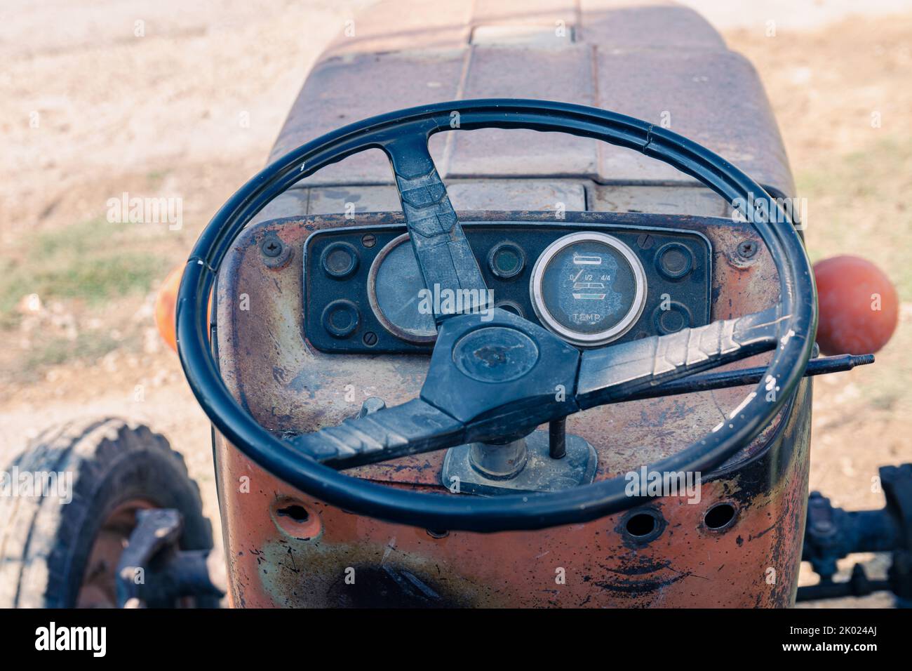 Alte rote Oldtimer-Traktor mit offenem Fahrerhaus. Foto eines ländlichen Traktors ohne Fahrerhaus. Nahaufnahme der Vorderseite des Traktors: Kühler, Scheinwerfer. Stockfoto