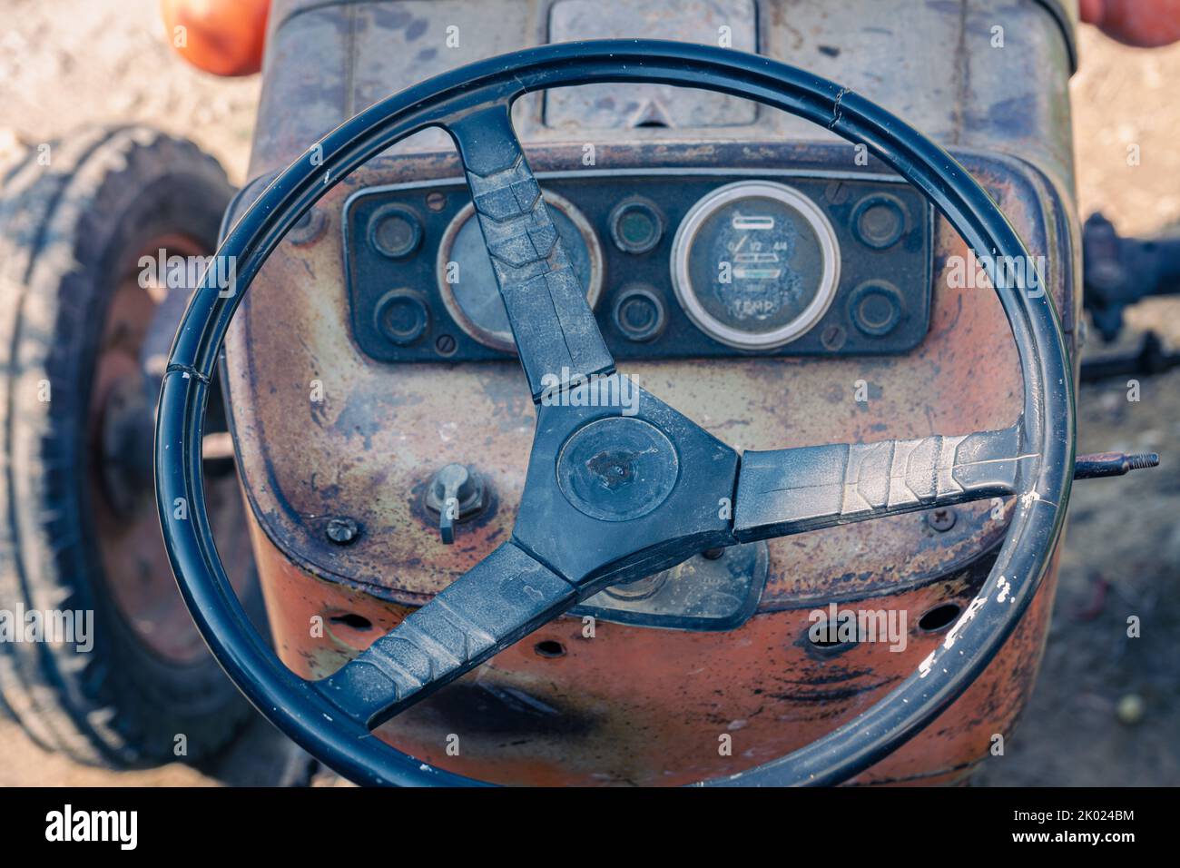 Alte rote Oldtimer-Traktor mit offenem Fahrerhaus. Foto eines ländlichen Traktors ohne Fahrerhaus. Nahaufnahme der Vorderseite des Traktors: Kühler, Scheinwerfer. Stockfoto