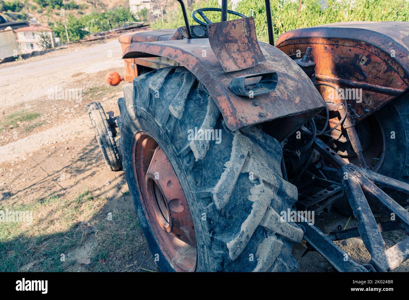 Alte rote Oldtimer-Traktor mit offenem Fahrerhaus. Foto eines ländlichen Traktors ohne Fahrerhaus. Nahaufnahme der Vorderseite des Traktors: Kühler, Scheinwerfer. Stockfoto