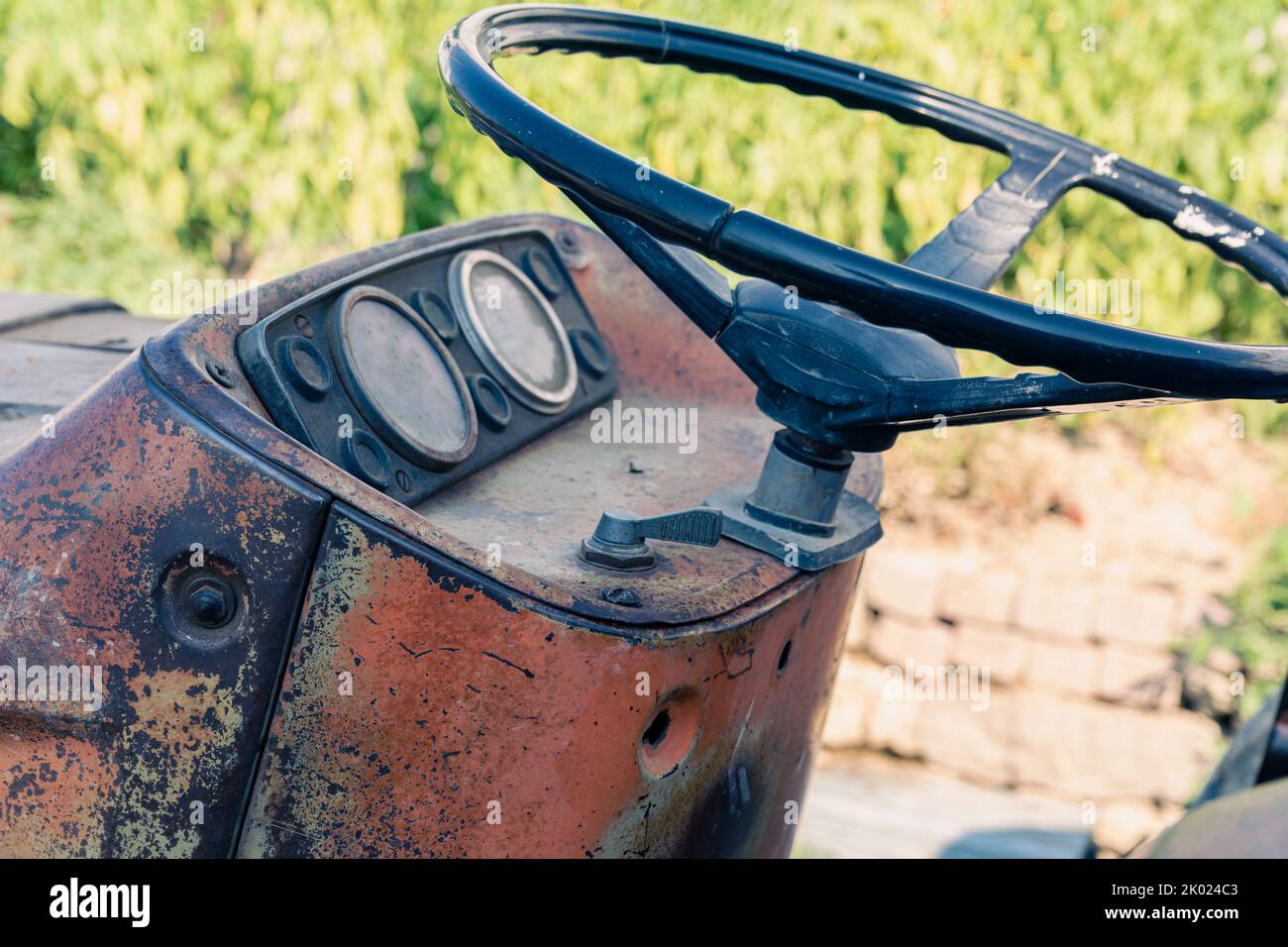 Alte rote Oldtimer-Traktor mit offenem Fahrerhaus. Foto eines ländlichen Traktors ohne Fahrerhaus. Nahaufnahme der Vorderseite des Traktors: Kühler, Scheinwerfer. Stockfoto
