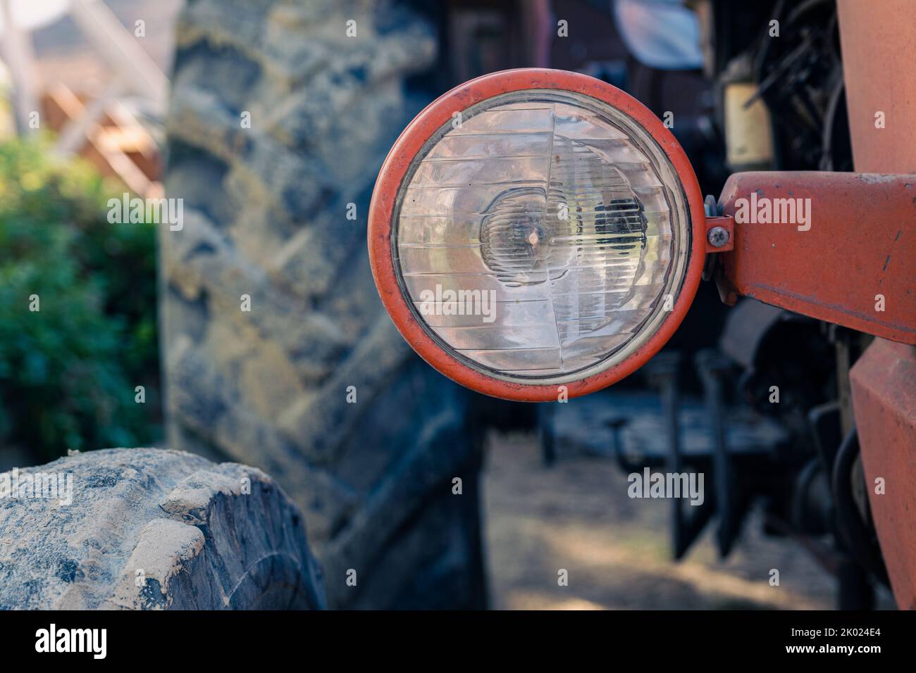 Alte rote Oldtimer-Traktor mit offenem Fahrerhaus. Foto eines ländlichen Traktors ohne Fahrerhaus. Nahaufnahme der Vorderseite des Traktors: Kühler, Scheinwerfer. Stockfoto