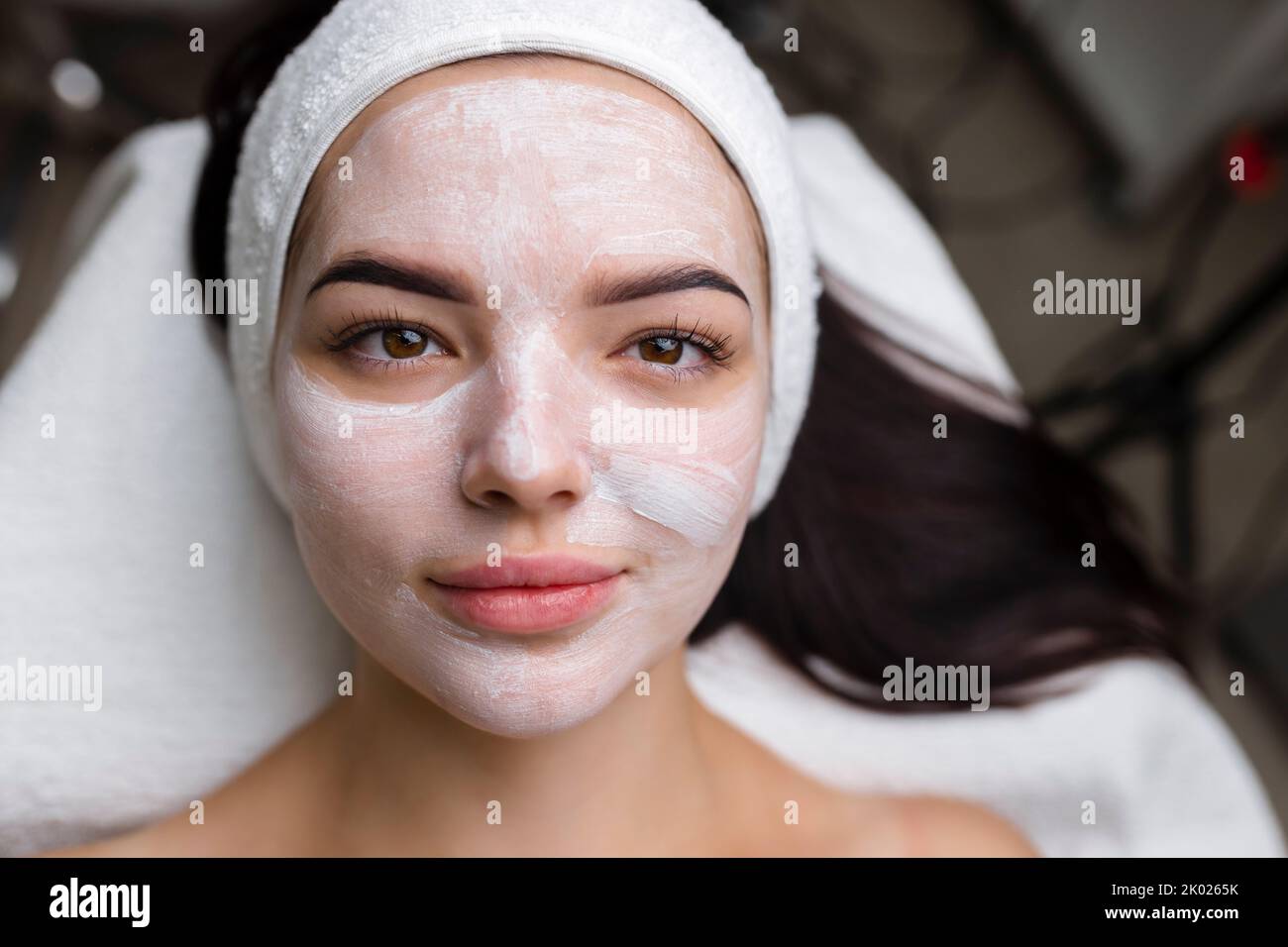 Nahaufnahme einer Frau, die eine Gesichtsbehandlung mit Tonmaske erhält. Kosmetologie und Spa Stockfoto