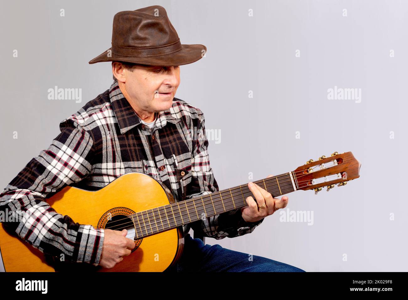 Foto eines alten Mannes, der Gitarre mit Gaucho-Hut spielt Stockfoto