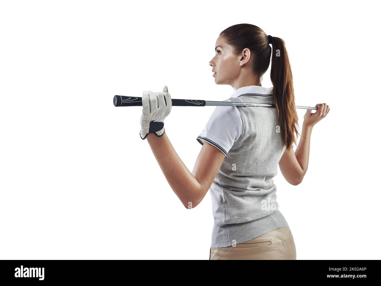 Königin des Clubs. Studioaufnahme einer jungen Golferin, die einen Golfschläger hinter ihrem Rücken in Weiß gehalten hat. Stockfoto