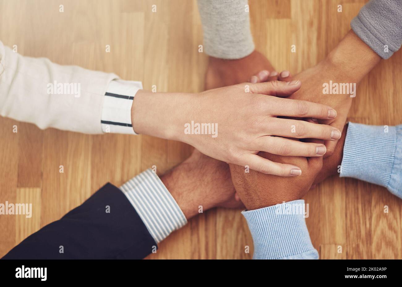 Stärke in Zahlen, Erfolg in Stärke. Eine Gruppe von Geschäftsleuten, die ihre Hände in Einheit zusammenlegen. Stockfoto