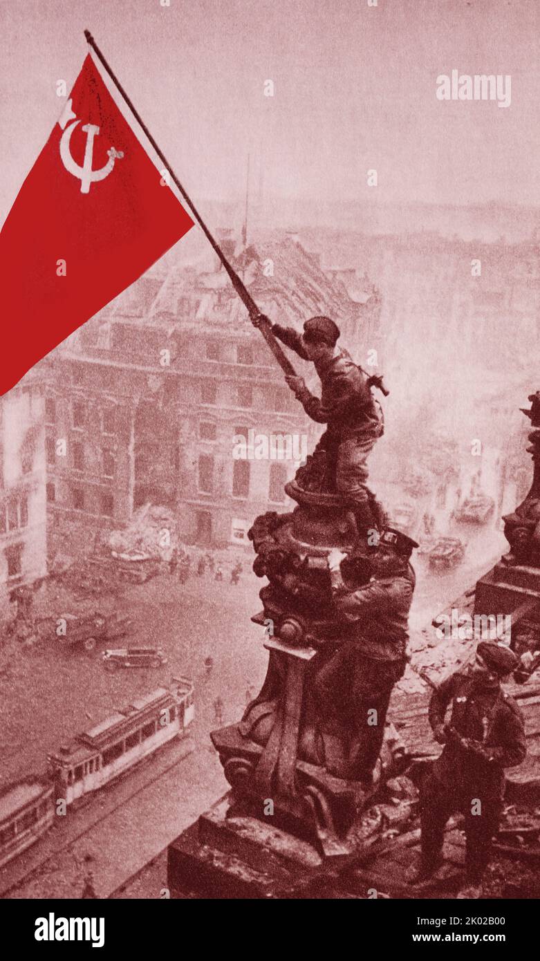 *Coloriert* am 30. April 1945 wurde das scharlachrote Siegesbanner über dem brennenden Reichstag in Berlin gehisst. Am 8. Mai wurde der Akt der bedingungslosen Kapitulation des faschistischen Deutschlands unterzeichnet. Die sowjetische Armee rettete die Völker Europas vor der faschistischen Sklaverei. Stockfoto