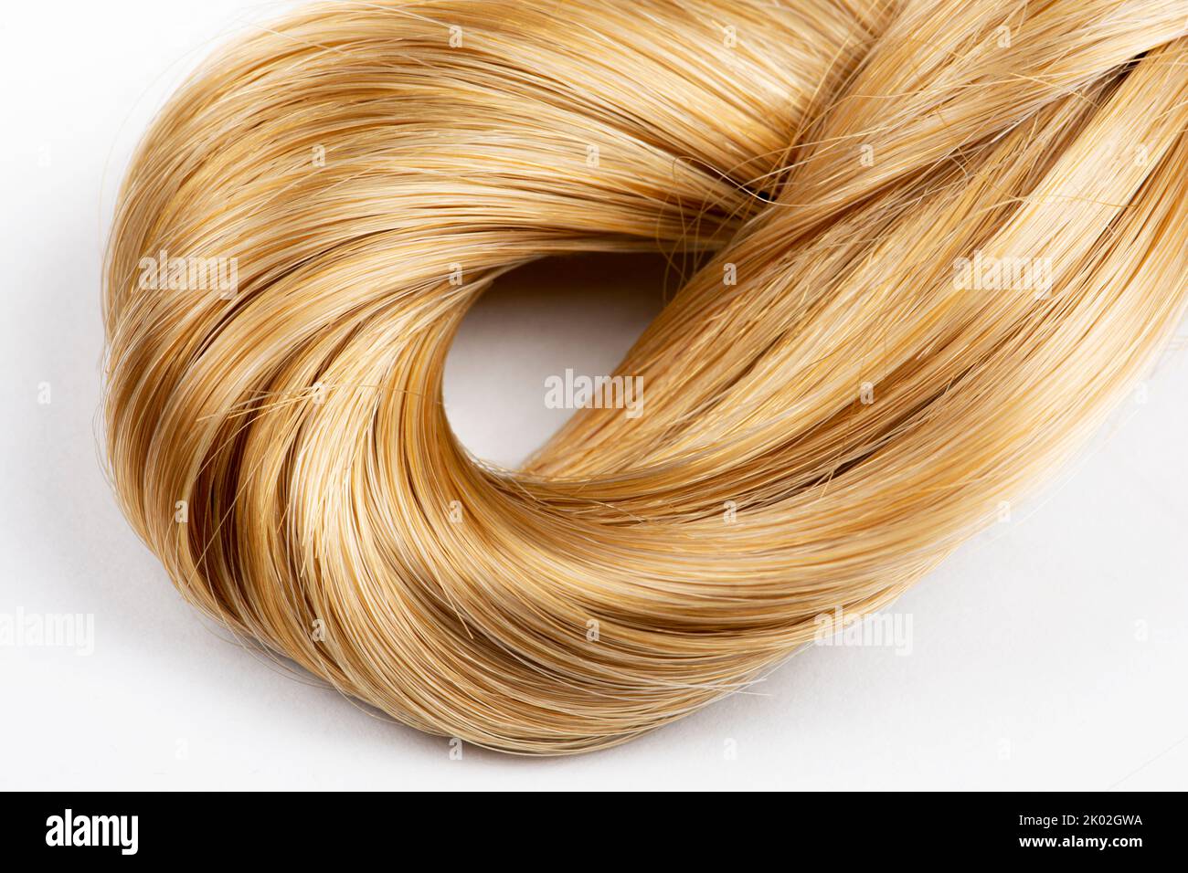 Blonde Haare in Knoten auf weißem Hintergrund gebunden Stockfoto