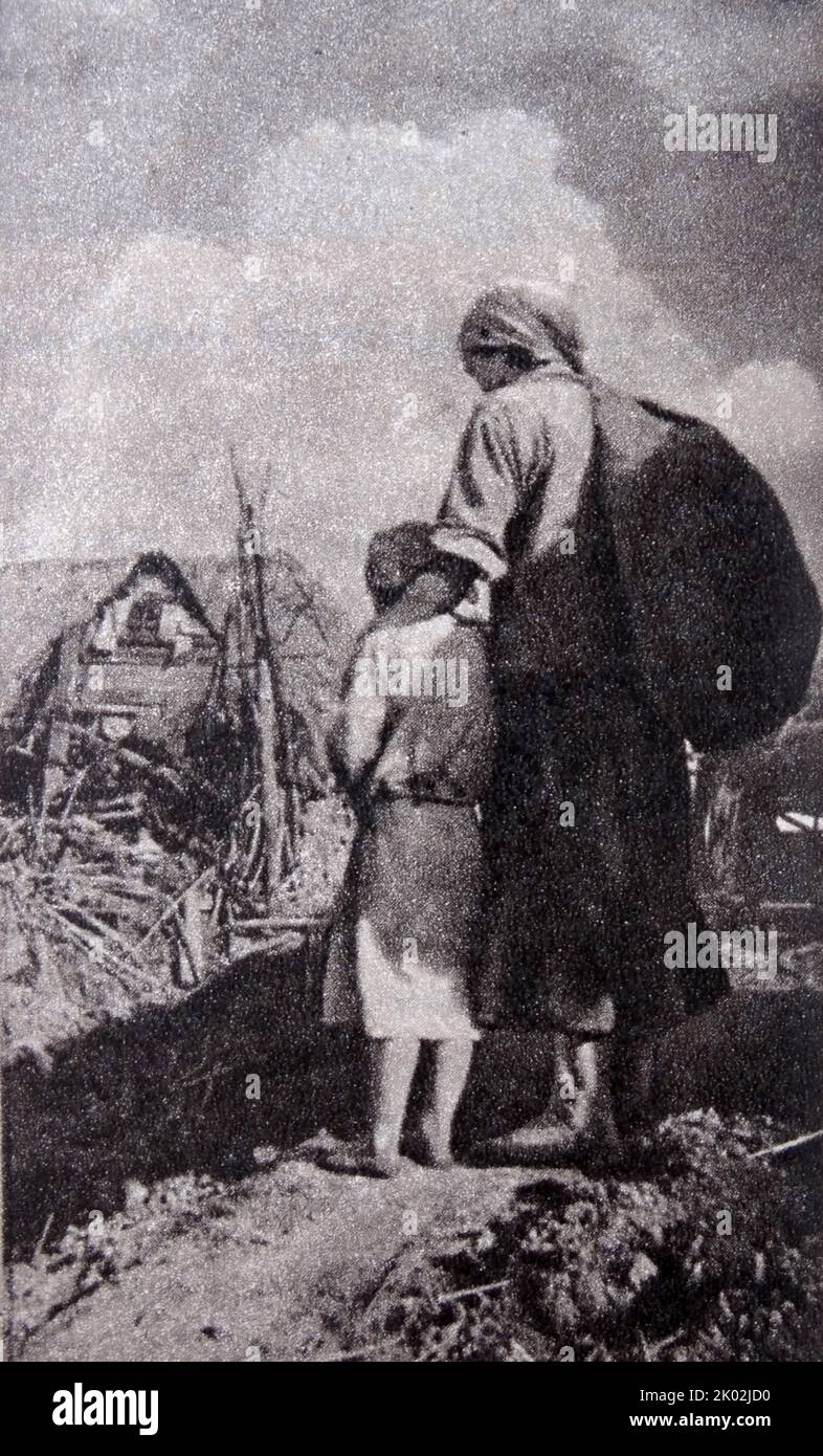 Russische Mutter und Kind blicken auf die Ruinen ihres Hauses nach dem deutschen Einmarsch in die UdSSR 1941 Stockfoto